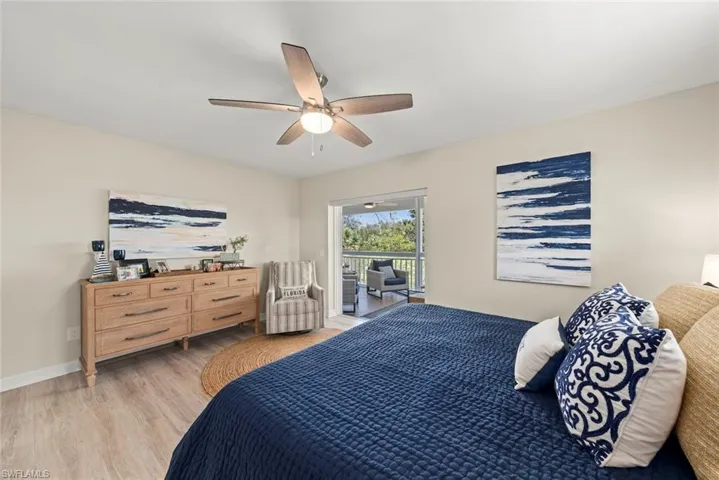 Spacious room featuring wood-finish flooring, a contemporary ceiling fan, and sliding glass doors opening to a screened outdoor space