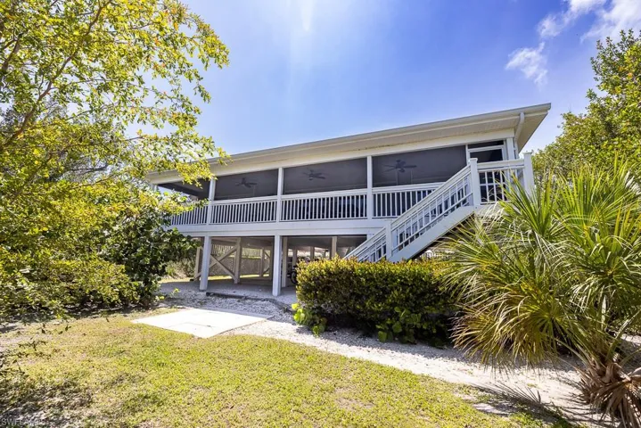 Elevated coastal residence with a screened-in porch and exterior stairway