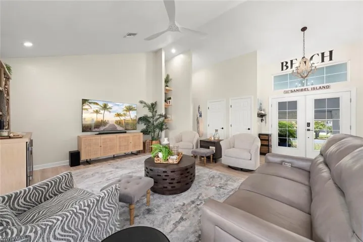 Vaulted ceiling living room featuring light wood-finish flooring, recessed lighting, and a contemporary ceiling fan