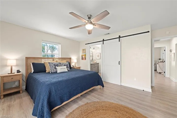 Bedroom featuring wood-finish flooring, a ceiling fan, and a window with blinds