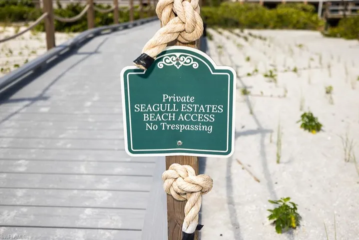 Private beach access sign with decorative border, mounted on a wooden post with rope detailing