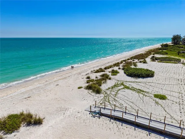 Expansive beachfront featuring white sand, turquoise waters, and natural dunes