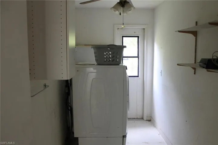 Laundry area with ceiling fan and washer / dryer