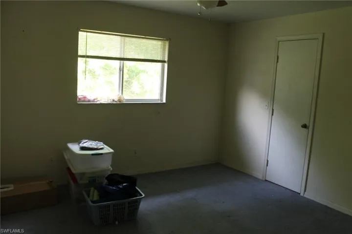 Carpeted empty room featuring ceiling fan