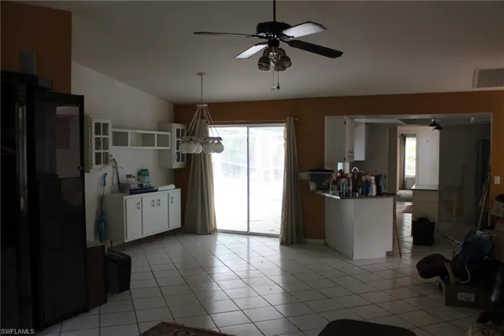Kitchen featuring a healthy amount of sunlight, white cabinetry, light tile flooring, and pendant lighting