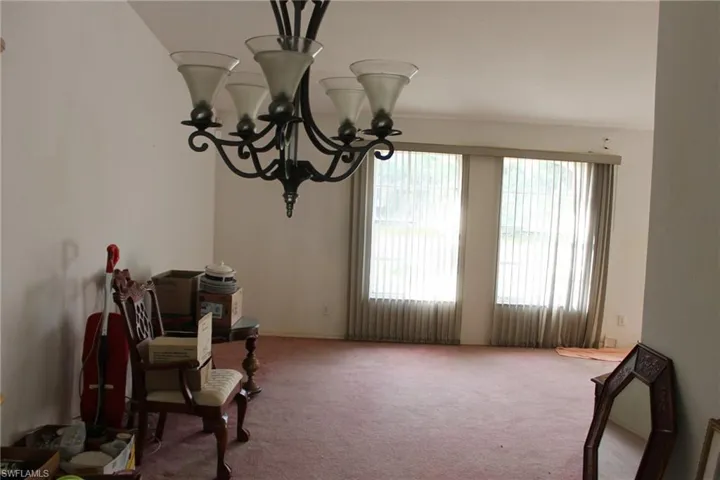 Sitting room featuring carpet flooring and a notable chandelier