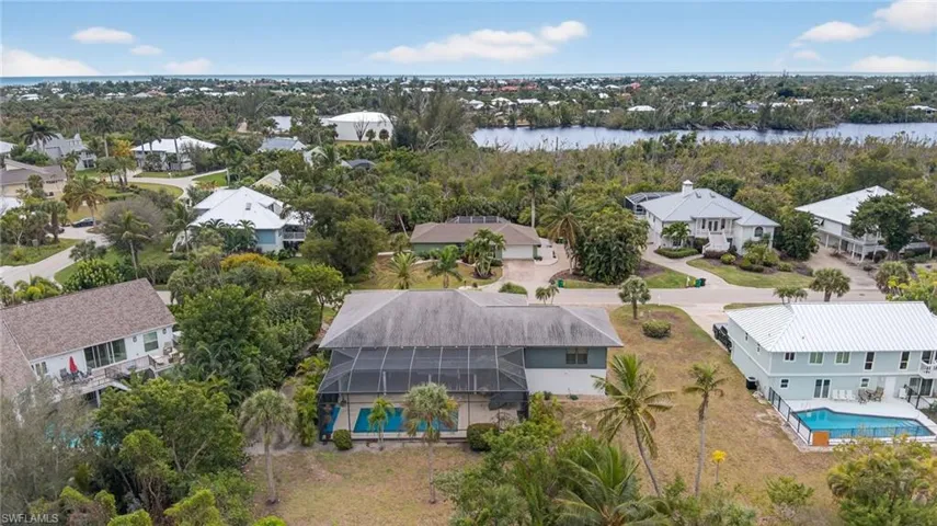 Aerial perspective of suburban area with a pool and a nearby body of water
