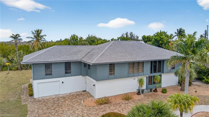View of front of house with roof with shingles, a garage, stucco siding, and driveway