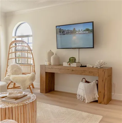 Living area with ornamental molding, wood finished floors, and a textured ceiling