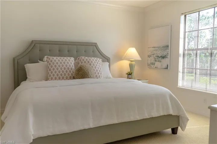 Bedroom featuring crown molding, baseboards, multiple windows, and carpet flooring