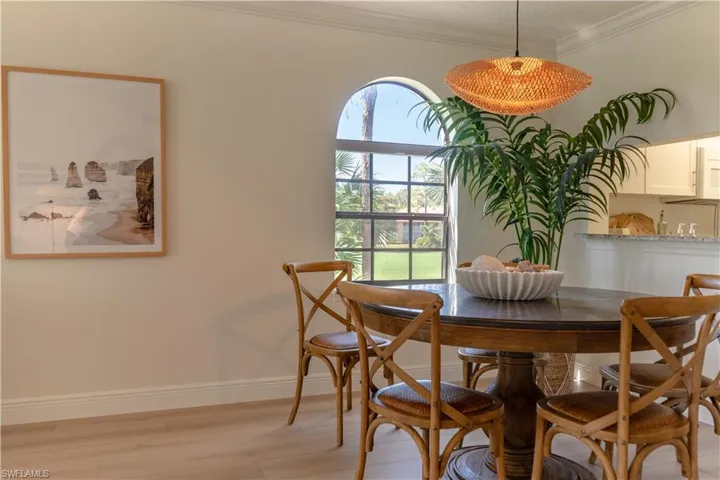 Dining room featuring light wood-style floors, baseboards, and ornamental molding