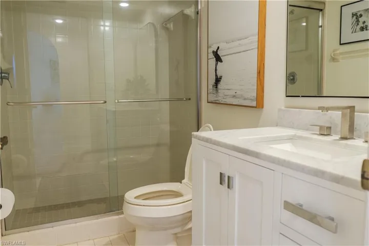 Full bath with toilet, a stall shower, and vanity