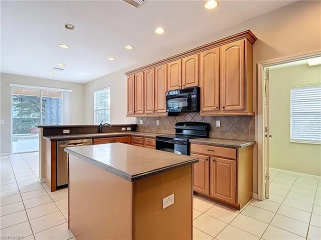 Kitchen with black appliances, a peninsula, healthy amount of natural light, recessed lighting, and light tile patterned flooring