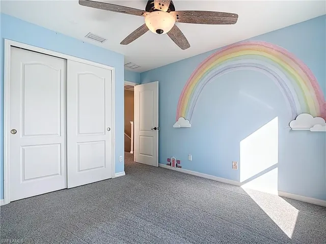Unfurnished bedroom with carpet floors, a closet, and ceiling fan