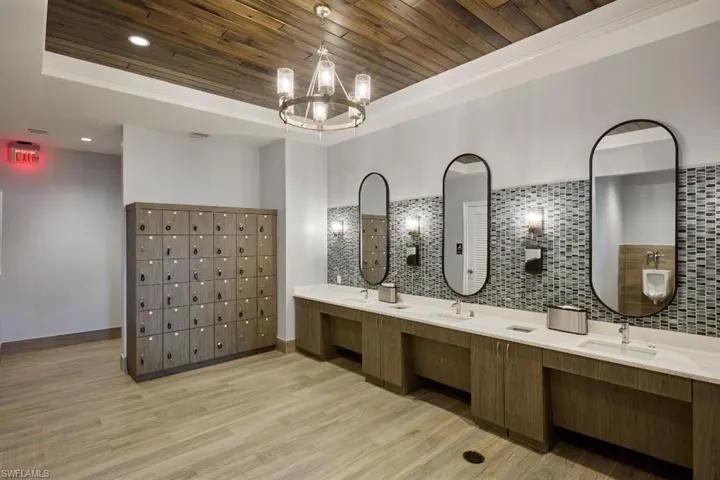 Bathroom with a tray ceiling, hardwood / wood-style floors, vanity, and a chandelier