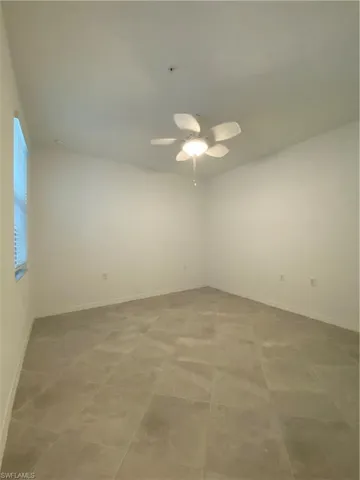 Empty room with tile patterned flooring and ceiling fan