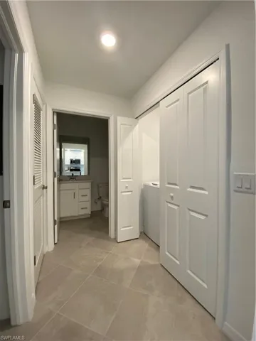Corridor featuring light tile patterned flooring