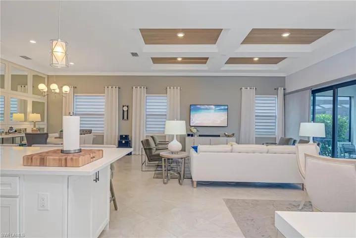 Living room with beam ceiling, an inviting chandelier, crown molding, coffered ceiling, and wood ceiling