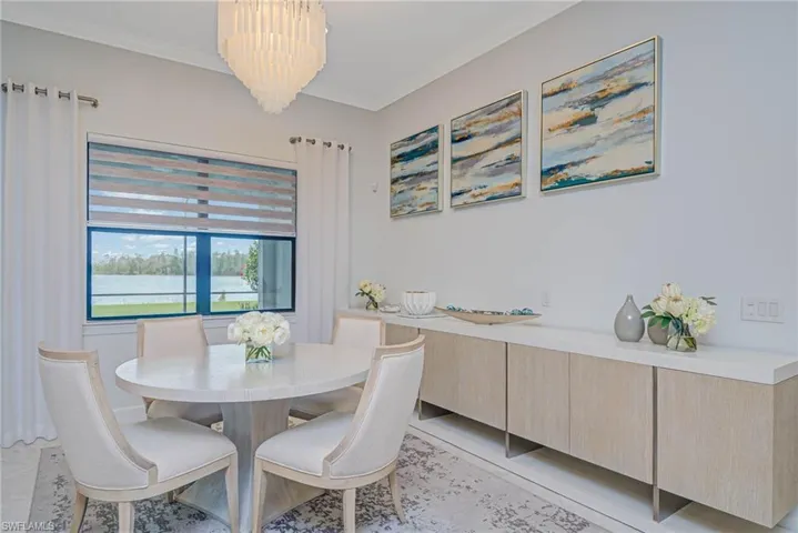 Dining room featuring light tile patterned flooring, a chandelier, and ornamental molding