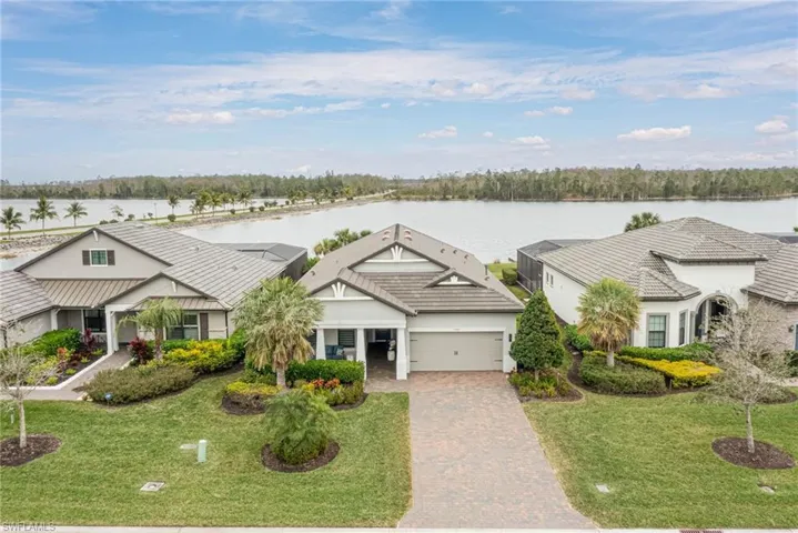 View of front of property with a water view, a front yard, and a garage