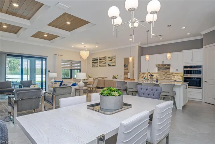 Dining room featuring crown molding, coffered ceiling, and a notable chandelier