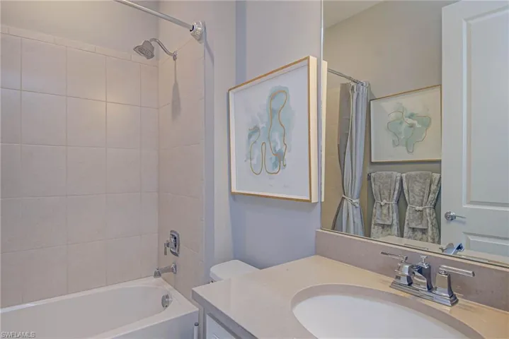 Full bathroom featuring toilet, vanity, and shower / bath combo with shower curtain