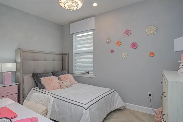 Bedroom featuring light hardwood / wood herringbone patterned flooring