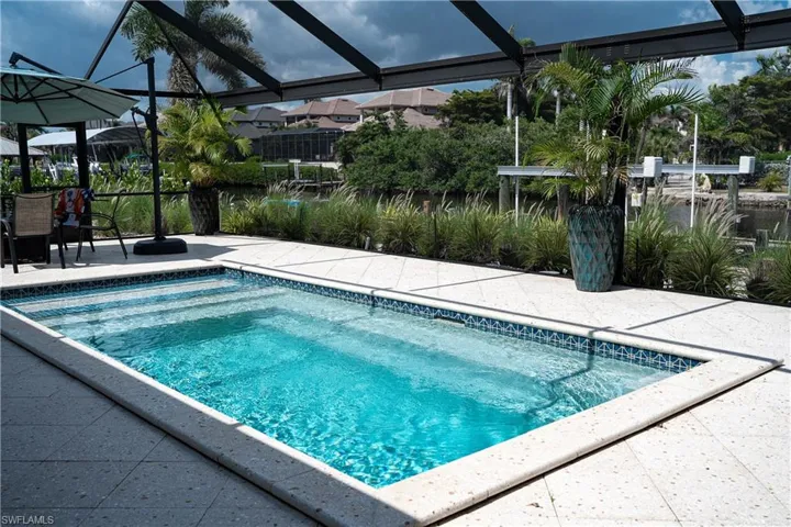 Swimming pool featuring a lanai, a patio area, and a sunroom