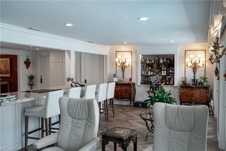 Living area featuring parquet flooring, a dry bar, recessed lighting, and ornamental molding