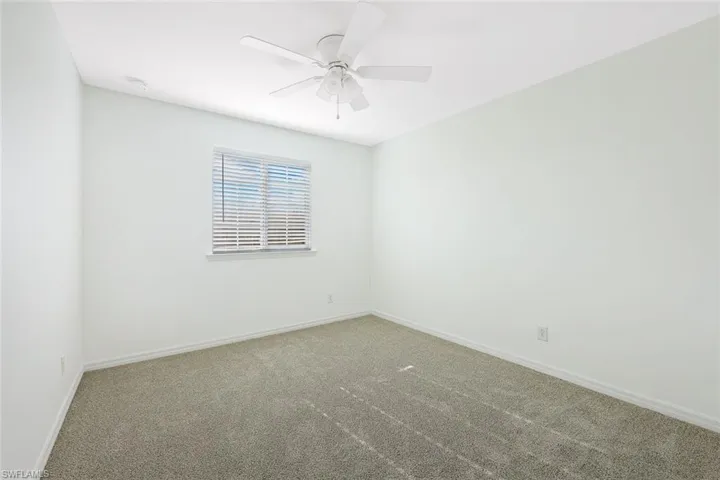 Spare room with carpet and a ceiling fan
