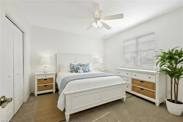 Carpeted bedroom with a closet and ceiling fan