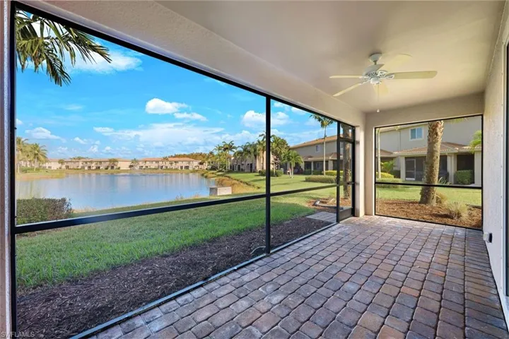 Unfurnished sunroom featuring a water view and a ceiling fan