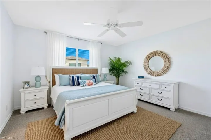 Bedroom with light colored carpet and ceiling fan