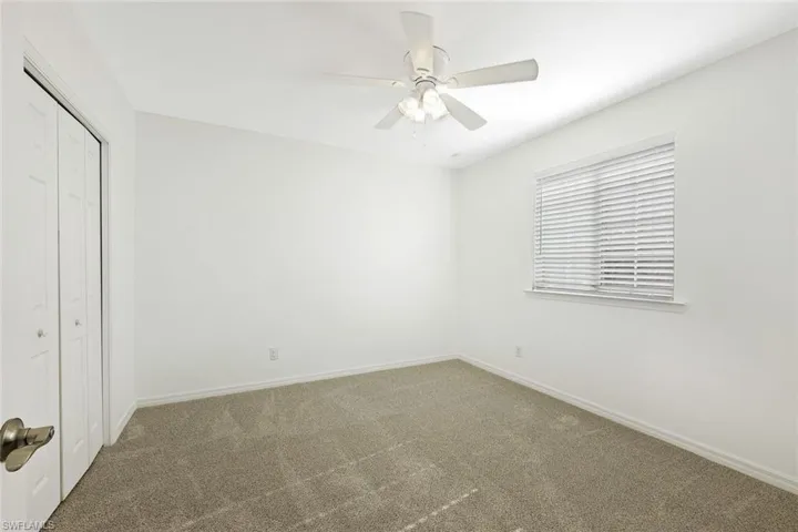 Unfurnished bedroom featuring a closet, carpet floors, and a ceiling fan