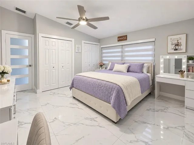 Vaulted ceiling with a ceiling fan, white paneled doors, modern interior door with frosted glass panels, and large format tile flooring