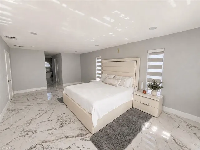 Spacious room featuring large format stone-finish flooring, recessed lighting, and roller blinds