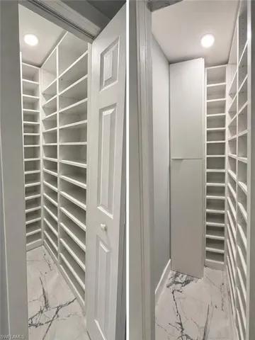 Built-in shelving system with extensive storage, recessed ceiling lighting, and panel interior door