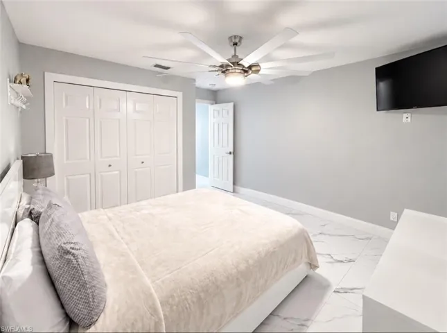 White paneled bi-fold closet doors, ceiling fan with integrated lighting, and light-toned walls