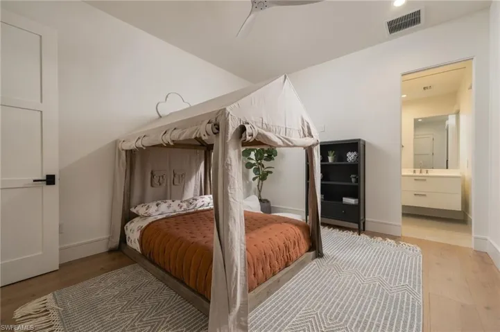 Light wood-finish flooring, white walls, and a contemporary ceiling fan