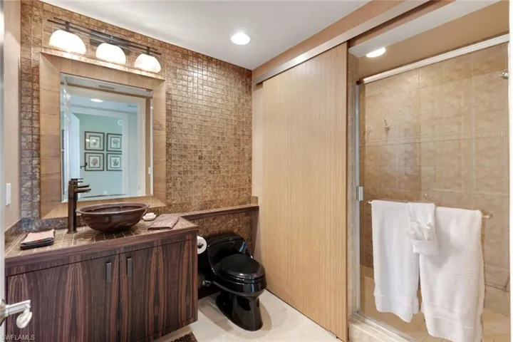 Full Bath on Hall with Sliding Door Revealing Walk-in Shower