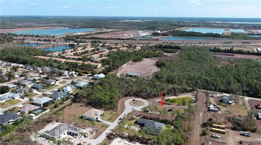 Aerial view of property's location featuring a nearby body of water and nearby suburban area