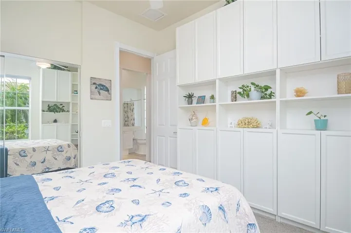 Bedroom with carpet floors, ceiling fan, and ensuite bath