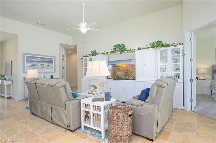 Living room with ceiling fan and light tile floors