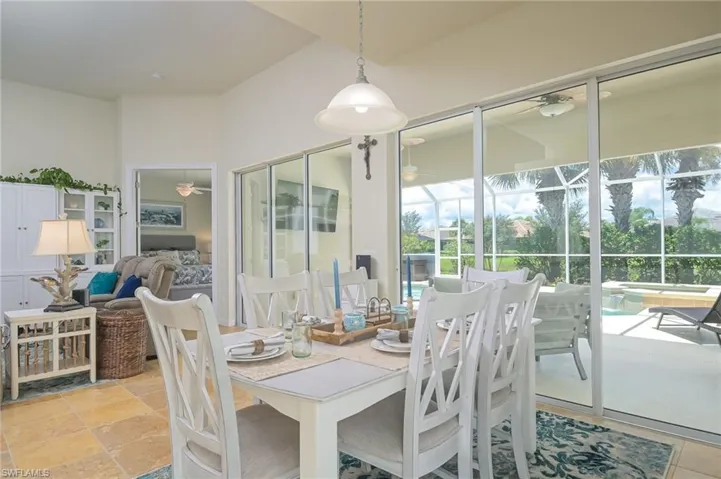 Tiled dining space with a healthy amount of sunlight and ceiling fan