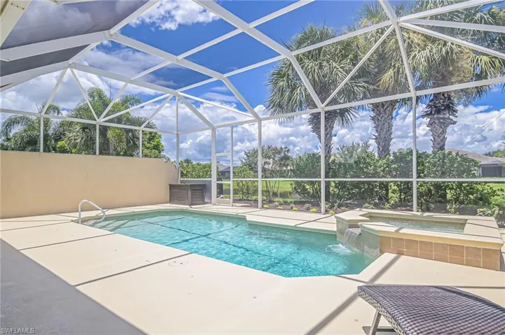 View of pool with pool water feature, enclosure, an in ground hot tub, and a patio
