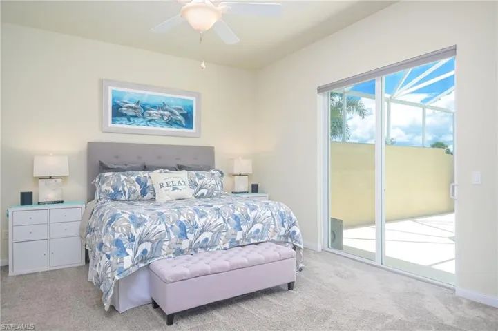 Carpeted bedroom featuring ceiling fan and access to exterior