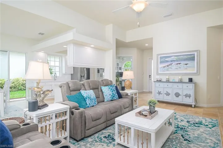 Tiled living room with plenty of natural light, ceiling fan, and sink