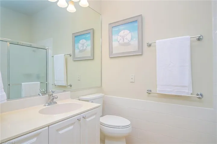 Bathroom featuring tile walls, toilet, and oversized vanity