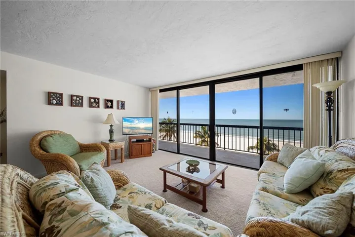 Living room featuring floor to ceiling windows, a textured ceiling, and carpet