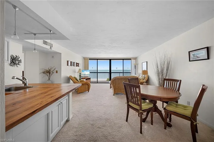 Dining space featuring a wall of windows and light carpet